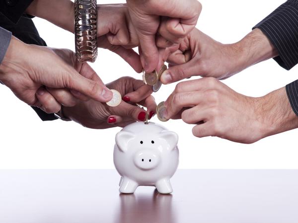 various people putting money into a piggy bank