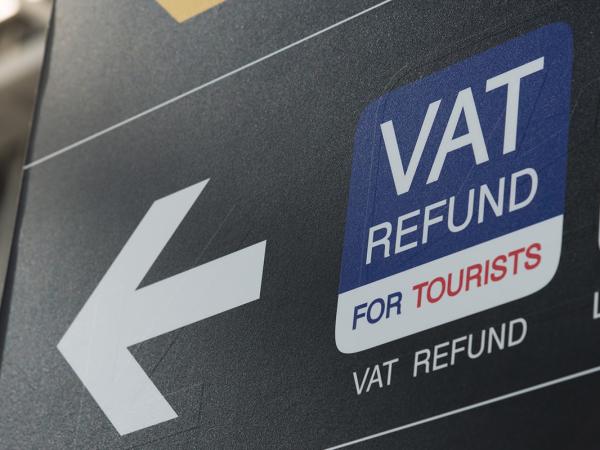 a sign with an arrow pointing to the left the wording reads 'VAT REFUND FOR TOURISTS'