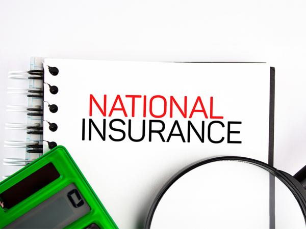 a wire bound notebook with the words 'NATIONAL INSURANCE' typed on the front in back and red text, a green calculator and a magnifying glass