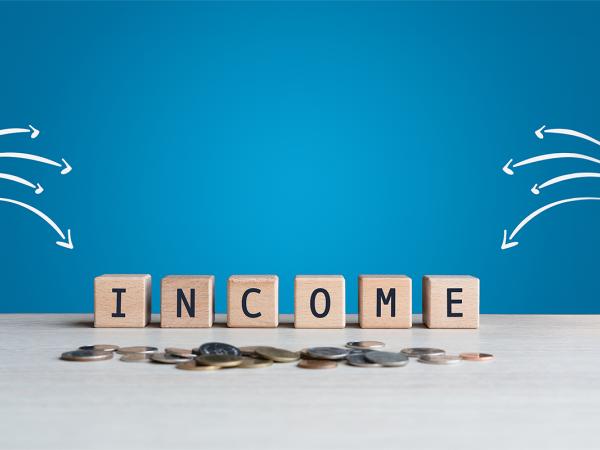 Wooden blocks spelling out the word 'INCOME' against a blue background, white arrows are pointing towards the word.