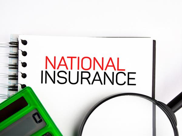 a wire bound notebook with the words 'NATIONAL INSURANCE' typed on the front in back and red text, a green calculator and a magnifying glass