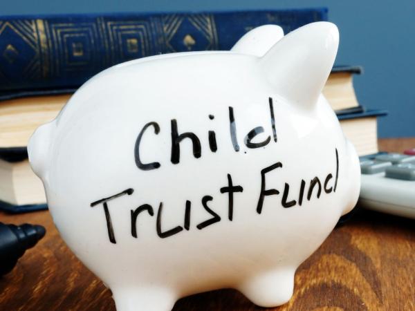 white piggy bank with the words 'CHILD TRUST FUND' written in black ink.
