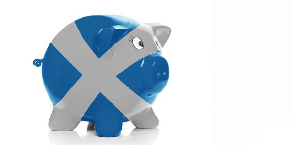 a ceramic piggy bank on a white background decorated with the Scottish flag