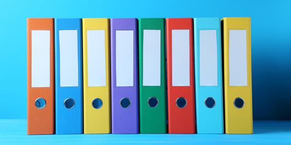 8 coloured folders lined up against a light blue background.