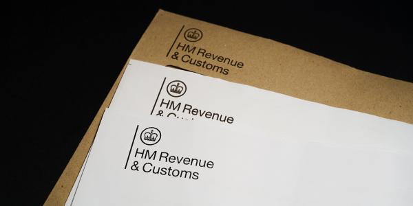 a brown envelope from HMRC along with 2 white pieces of paper headed with the HMRC logo in the top left.
