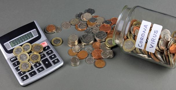 Image of a jar of coins with the word coronavirus on it next to a calculator Image of a jar of coins with the word coronavirus on it next to a calculator