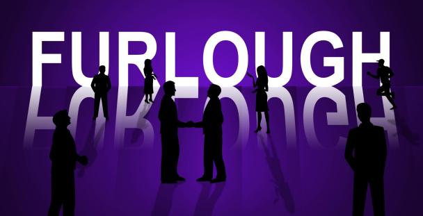 Silhouette of workers standing in front of the word furlough during coronavirus outbreak Silhouette of workers standing in front of the word furlough during coronavirus outbreak