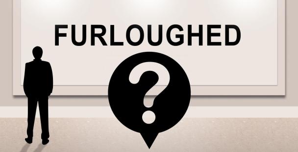 furloughed man standing in front of sign furloughed man standing in front of sign