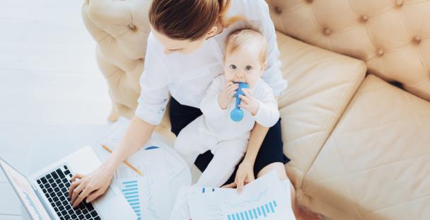 Image of a woman working with baby on her lap Image of a woman working with baby on her lap