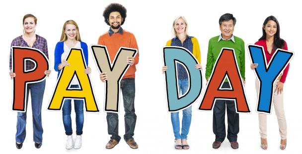 People holding letters spelling pay day People holding letters spelling pay day