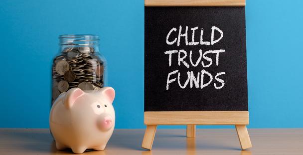 Image of a piggy bank and a board with the words child trust funds written on it Image of a piggy bank and a board with the words child trust funds written on it