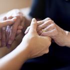 A young person holding hands with an older person. ©istock/PeopleImages
