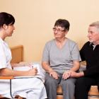 Carer-helping-elderly-couple