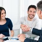 Woman and man, with man shaking hands with man wearing a suit