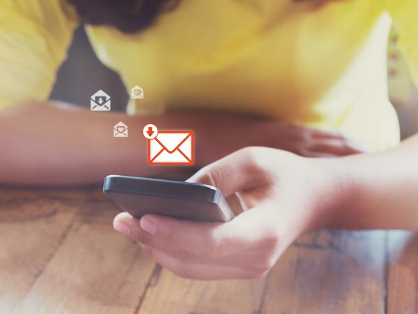 Woman holding a smartphone, with email symbol displayed