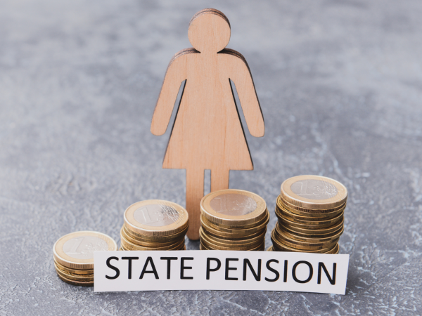 wooden figure of a person stood besides a stack of coins with a typed sign that reads 'state pension'