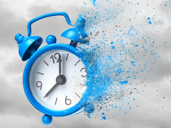 grey clouds in the background with a blue clock fading away into dust