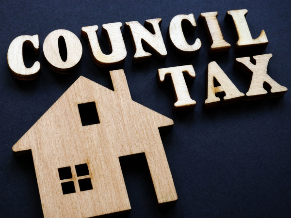 a house and the words 'council tax' carved from wood against a navy blue background