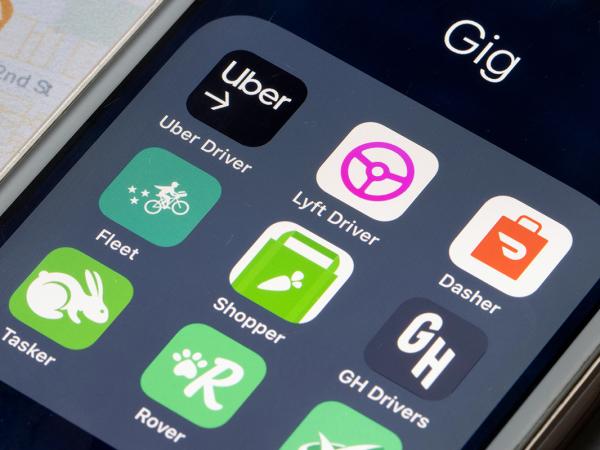 a phone showing apps for gig economy such as 'UBER', 'LYFT DRIVER', 'DASHER', 'FLEET', 'SHOPPER', 'GH DRIVERS', 'TASKER', 'ROVER' and another that cannot be seen.