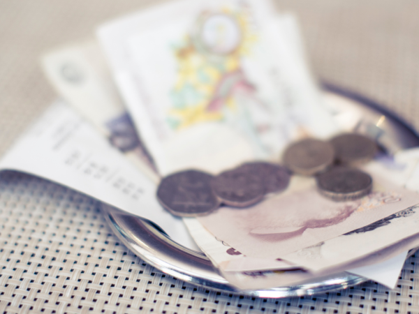 silver plate containing receipt, cash and coins. 
