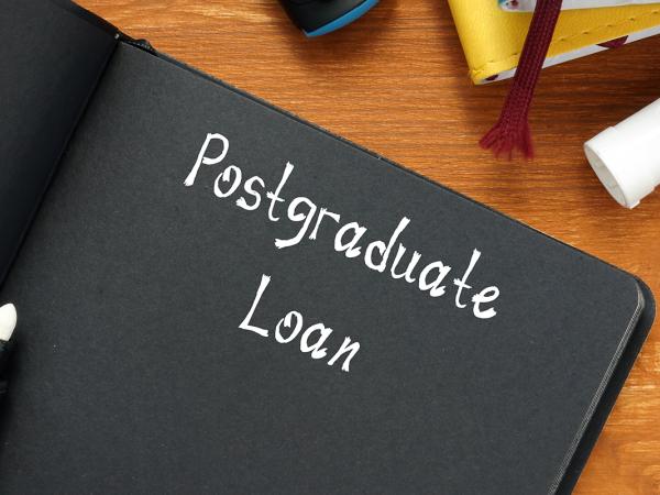 a black notebook with white writing inside. writing says 'POSTGRADUATE LOAN'