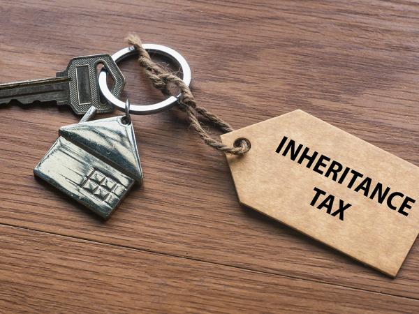 a bundle with a key, a key ring of a metal house and wooden key ring with the words 'INHERITANCE TAX' 