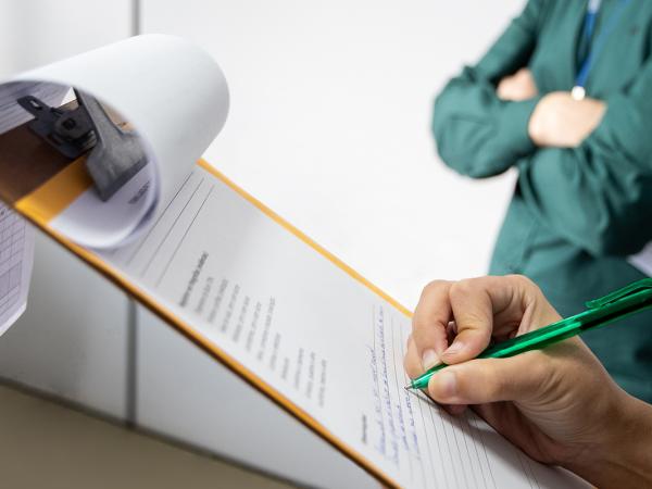 a person taking notes on a clipboard. 