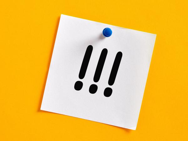 a yellow background, with a white piece of paper pinned to it, the paper shows 3 exclamation marks