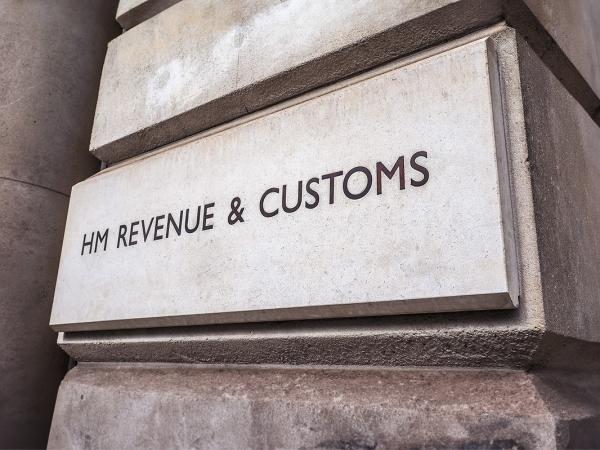 an image of the outside of HMRC office building. The words 'HM REVENUE & CUSTOMS' can be seen on the stone wall