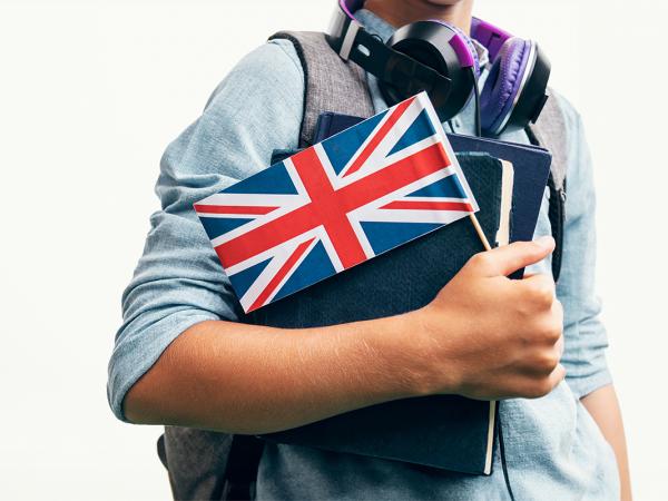 a student carrying books and a flag of the United Kingdom