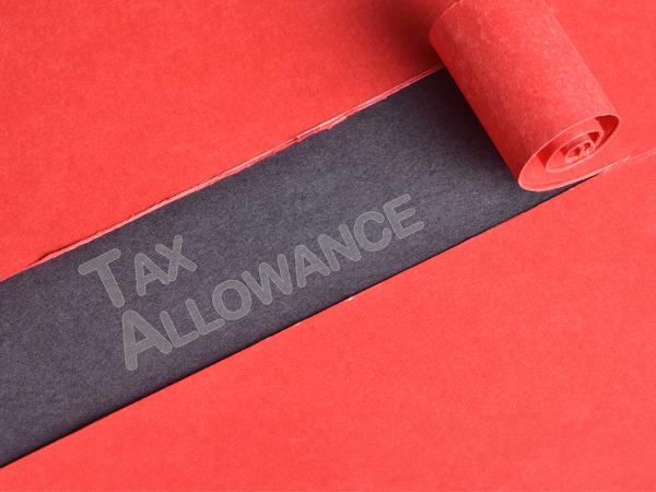 red material with a section peeled back to reveal a black background with the words 'TAX ALLOWANCE' written in grey text