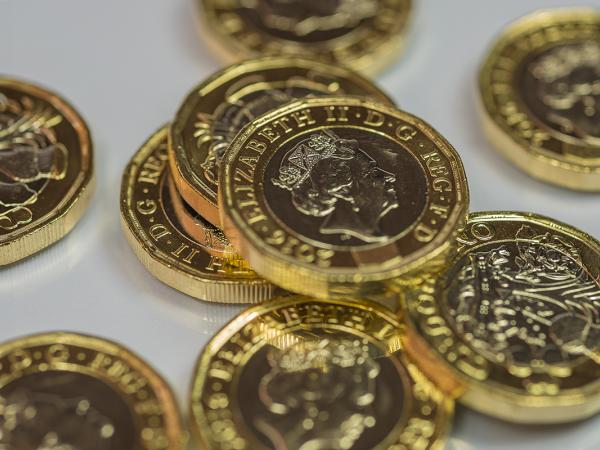 pound coins scattered against a white background. 
