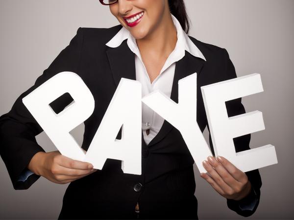 A person holding large white letters to spell the word 'PAYE' 