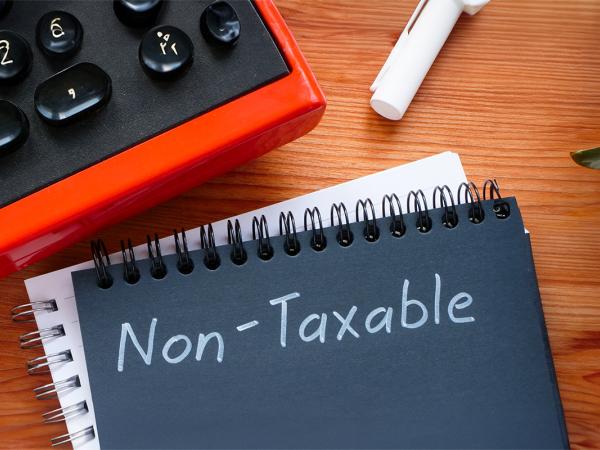 a black pad of paper on a desk with the word 'NON-TAXABLE' written in white pen.