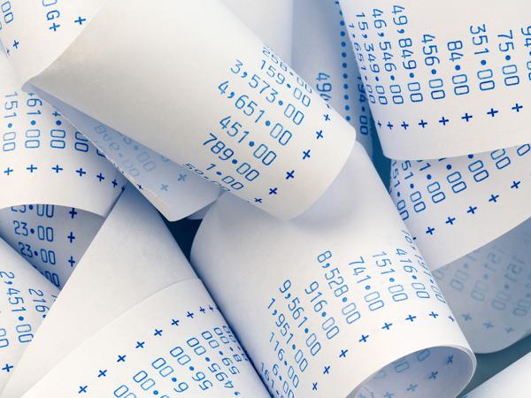 a bundle of calculations on receipt paper. 