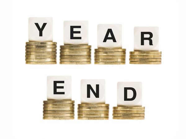 7 piles of coins, each with a dice on top, instead of showing dots to represent numbers, they show letters spelling out 'YEAR END' 