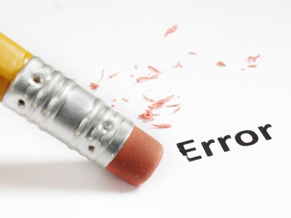 the word 'ERROR' written on a sheet of paper, with a pencil eraser rubbing it out. 