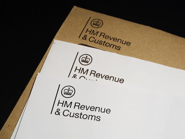 a brown envelope from HMRC along with 2 white pieces of paper headed with the HMRC logo in the top left.
