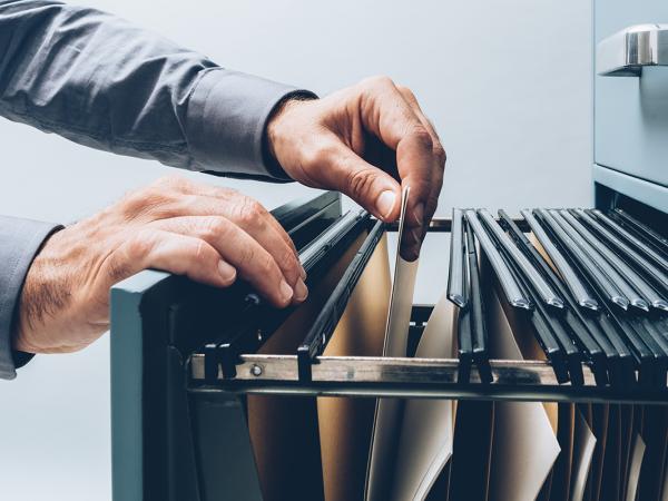 a person looking through a filing cabinet