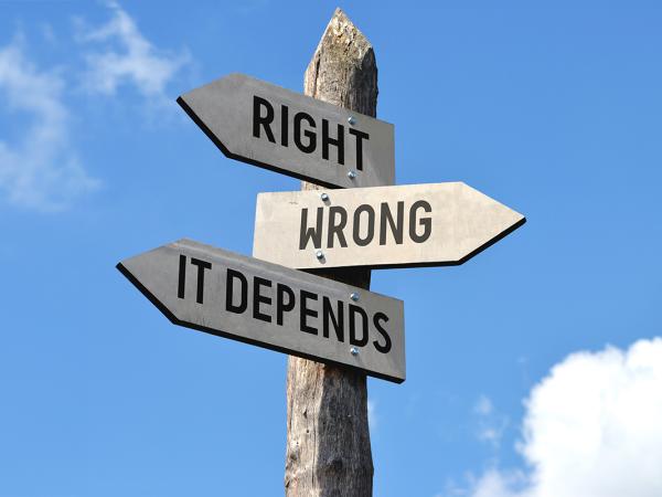 a wooden street sign with arrows pointing in different directions, the signs read 'RIGHT', 'WRONG' and 'IT DEPENDS'