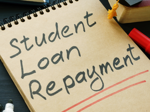 pad of paper with the words 'STUDENT LOAN REPAYMENT' written on it in black ink. 