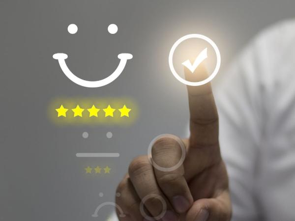 Stars and a smile symbol on a screen - with a finger pointing to a tick on the screen.