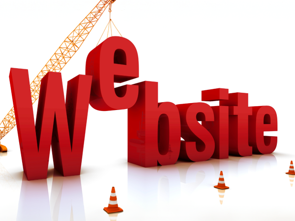 the word 'WEBSITE' being constructed by use of a crane, traffic cones can be seen around the word. 