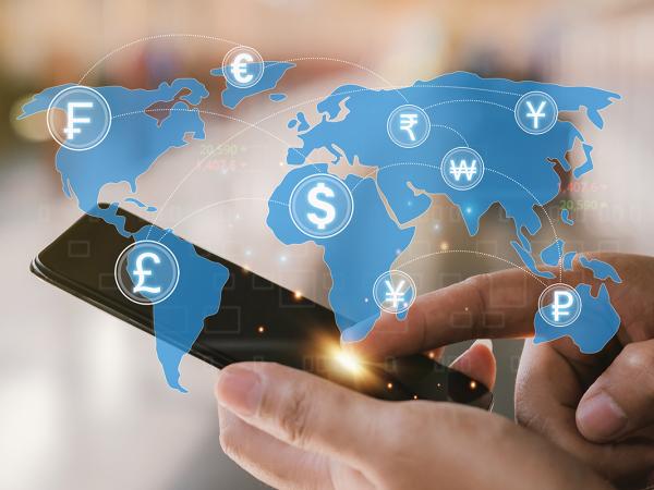 a person holding a phone, a world map is projected in the air showing many different currency symbols