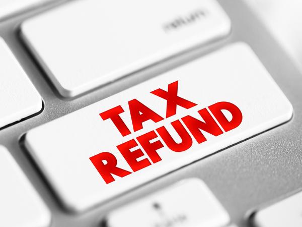 a computer keyboard, one key has red text that reads 'TAX REFUND' 