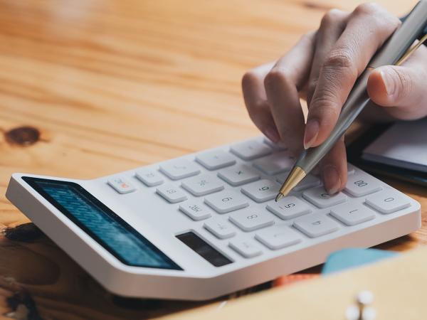 A person typing on a calculator 