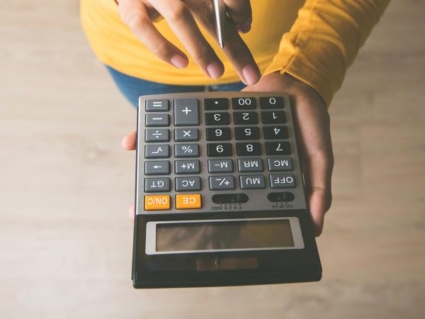 A person typing on a calculator.