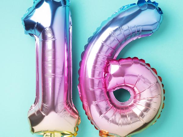 Birthday balloons of the number '16' against a blue background. 