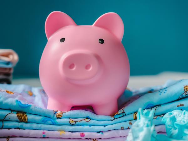 A pink piggy bank surrounded by children's items. 