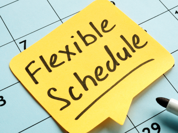 A calendar with a yellow post-it note, the note reads 'FLEXIBLE SCHEDULE' in black ink.